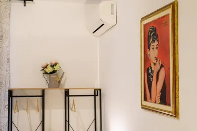 a painting of a woman on a wall next to a table at Trastevere Home Garibaldi 14 in Rome