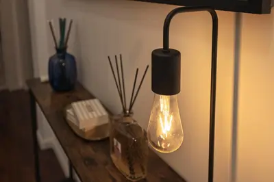a light hanging from a wall with two vases on a table at Domus Flavia Monti in Rome
