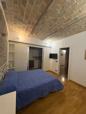 a bedroom with a bed with a blue bedspread at Guest House David San Lorenzo in Rome