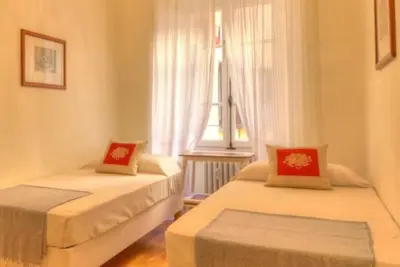 two beds in a room with a window at Via Veneto Cosy House in Rome