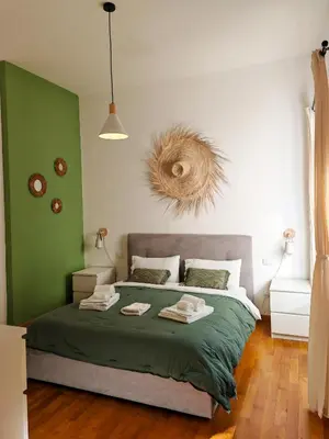 a bedroom with a bed with green and white walls at La Casetta A Monti Di Creta in Rome