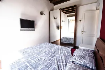 a bedroom with a bed and a television and a mirror at Scent Of Trastevere in Rome