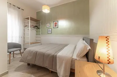 a bedroom with a bed and a desk and a chair at Il Nido di Roma - Ospedale Gemelli & Garden in Rome