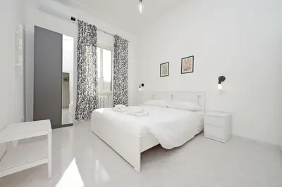 a white bedroom with a white bed and a window at New Comfortable 2 Br Della Vittoria by Halldis in Rome
