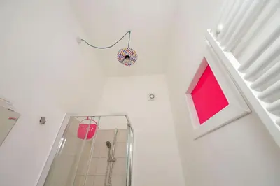 a bathroom with a shower and a pink wall at New Comfortable 2 Br Della Vittoria by Halldis in Rome
