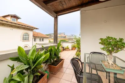 a balcony with a table and chairs and plants at Elegant Penthouse with Terrace in Rome