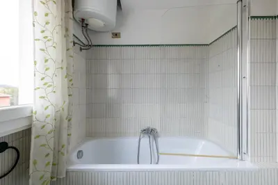 a bath tub in a bathroom with a shower curtain at Elegant Penthouse with Terrace in Rome