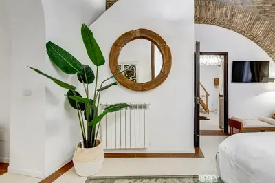 a living room with a mirror and a plant at NEW ROMAN Apartment - Rome Dream Home in Rome