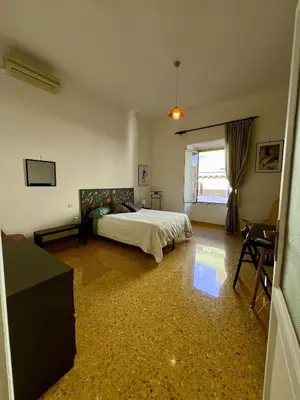 a bedroom with a bed and a table and a window at Emilia's home in Rome