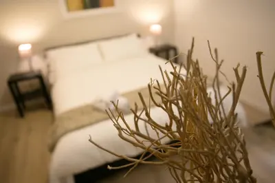 a bedroom with a bed and a plant in the foreground at Thebestinrome Piazza del Popolo - Vico in Rome