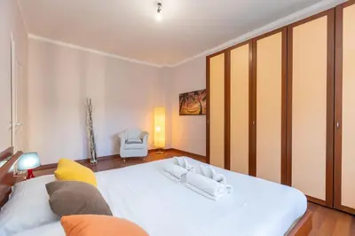 a bedroom with a large white bed and a chair at Altavilla by Rental in Rome in Rome