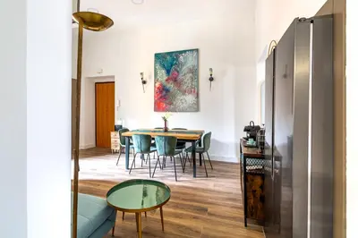 a dining room with a table and chairs and a painting at iFlat Brand New & Modern Central Station apt in Rome