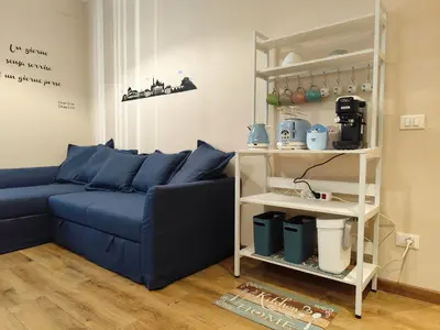 a living room with a blue couch and a shelf at La Casetta Battistini in Rome