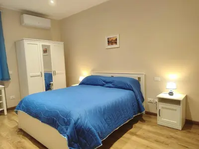a bedroom with a bed with a blue blanket at La Casetta Battistini in Rome