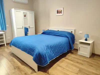 a bedroom with a bed with a blue blanket at La Casetta Battistini in Rome