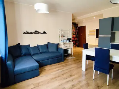 a living room with a blue couch and a table at La Casetta Battistini in Rome