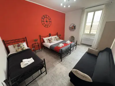 two beds in a room with red walls at Re Di Roma Retreat in Rome
