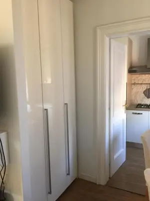 a white cabinet in a kitchen next to a door at Angelo ai Musei Vaticani studio in Rome