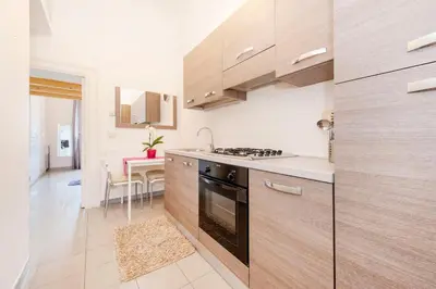 a kitchen with wooden cabinets and a stove at Cozy House near Termini Station - San Lorenzo in Rome