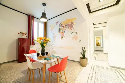 a dining room with a table and chairs with a map on the wall at The Pope's House in Rome