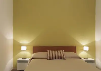 a bedroom with a bed with two lamps on both sides at Centro Roma Cortile - LOCAPPART in Rome