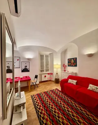 a living room with a red couch and a table at Ao Apartment in Rome
