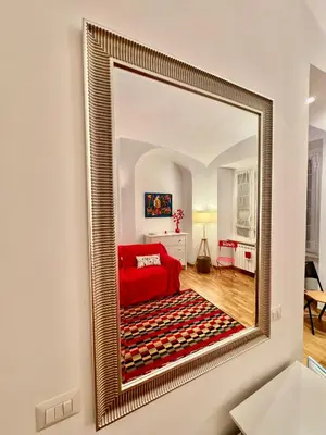 a large gold mirror on a wall in a living room at Ao Apartment in Rome
