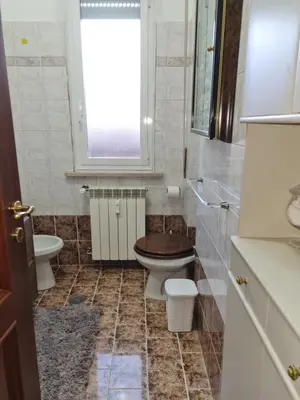 a bathroom with a toilet and a sink and a window at La Terrazza su Roma in Rome