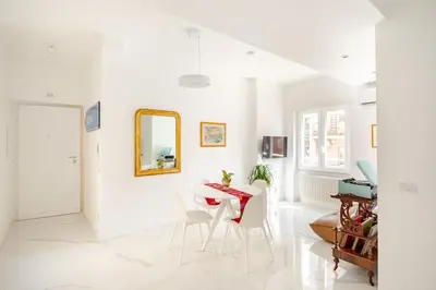 a white dining room with a table and chairs at Sunset House - San Paolo in Rome