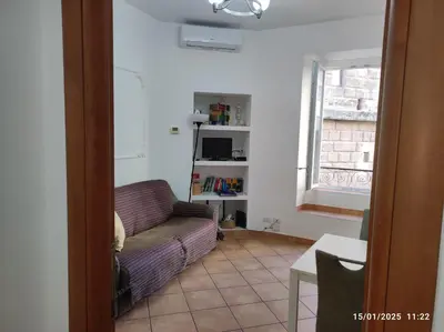 a living room with a couch and a window at Il Grillo ai Fori Romani in Rome