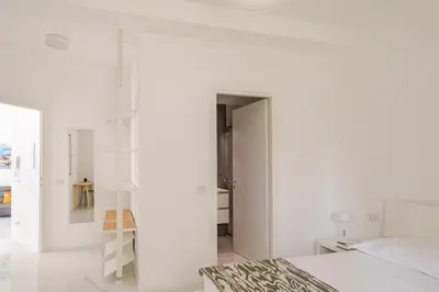 a bedroom with white walls and a white bed at Sunrise House - San Paolo in Rome