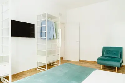 a bedroom with a bed and a tv and a chair at Suite 155 in Rome