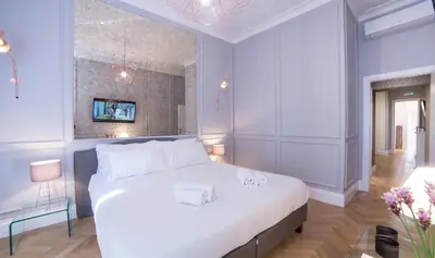 a bedroom with a large white bed and blue walls at Grand Master Suites in Rome
