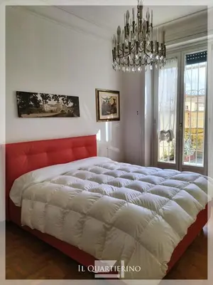 a bedroom with a large bed and a chandelier at Il Quartierino in Rome