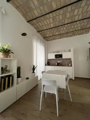 a white dining room with a table and chairs at Domus Machiavelli in Rome