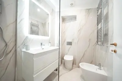 a white bathroom with a sink and a toilet at Apartment in Rione Ludovisi in Rome
