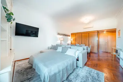 a white bedroom with a bed and a tv at Apartment in Rione Ludovisi in Rome