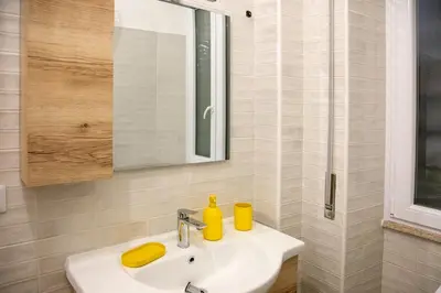 a white bathroom with a sink and a mirror at Casa Marini in Rome