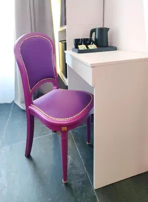 a purple chair sitting next to a desk at Prisma Rooms in Rome