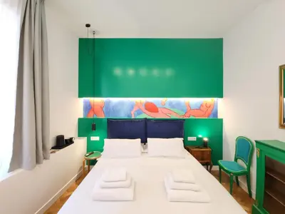 a room with a bed and a green wall at Prisma Rooms in Rome