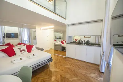 a bedroom with a large bed and a kitchen at Lovely Nest With Balcony by The Spanish Steps in Rome