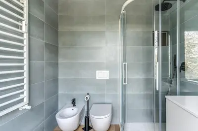 a bathroom with a toilet and a glass shower at 2 bedroom apartment Flaminio Vignola in Rome