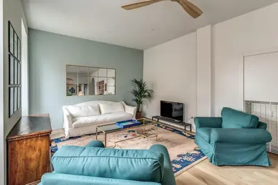 a living room with blue chairs and a couch at 2 bedroom apartment Flaminio Vignola in Rome