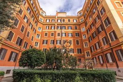 an orange building with trees in front of it at 2 bedroom apartment Flaminio Vignola in Rome