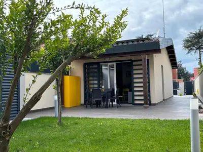 a small house with a patio and a table at Villino Ancillotto with garden and parking motorcycle space in Rome