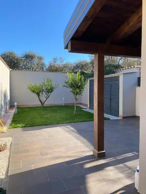 a patio with a fence and trees in a yard at Villino Ancillotto with garden and parking motorcycle space in Rome