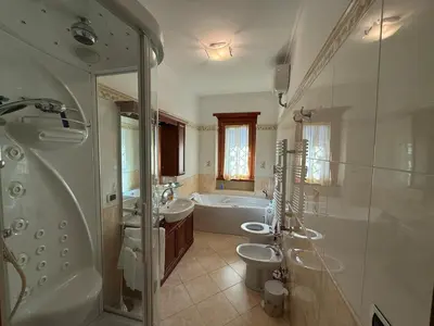 a bathroom with two sinks and a tub and a shower at Apartment in the heart of EUR in Rome