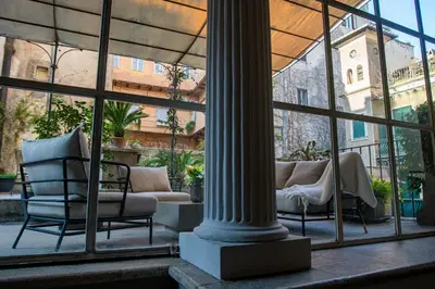 a room with chairs and a column and windows at Historical Palace Apartment with Large Terrace in Rome