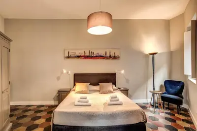 a bedroom with a bed and a blue chair at Campo di fiori 2 bedroom int 4 in Rome