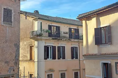 an old building with a balcony in a city at Colosseum Apartment Renovated Via Frangipane in Rome